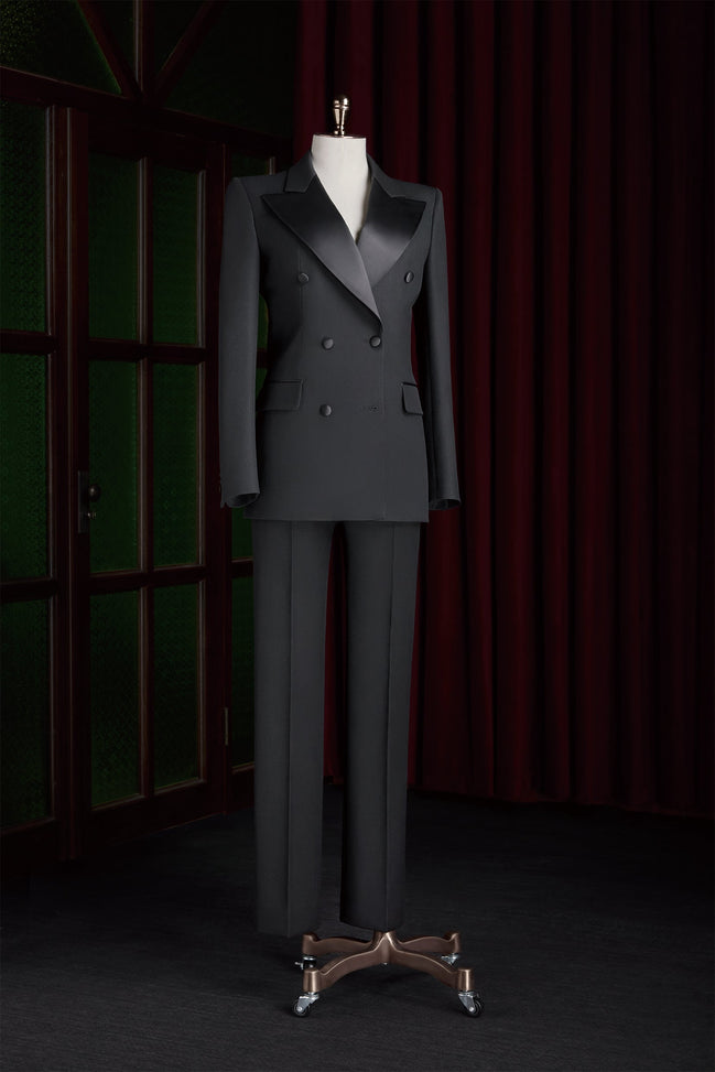 Women's black double-breasted tailored suit on a mannequin, featuring satin lapels and a structured fit, perfect for high-end formal events.