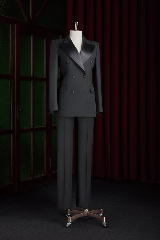 Women's black double-breasted tailored suit on a mannequin, featuring satin lapels and a structured fit, perfect for high-end formal events.