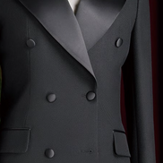 Close-up of women's black double-breasted suit with satin lapels, featuring elegant matte buttons and refined tailoring for a high-end formal look.