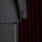 Close-up of women's tailored black suit sleeve with matte buttons and sleek pant detail, showcasing high-end craftsmanship and elegant design.