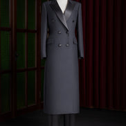 Women's long double-breasted black coat with satin lapels, tailored for formal events, showcasing high-end luxury and sustainable craftsmanship.