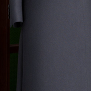 Close-up of women's black double-breasted overcoat with matte buttons and textured fabric, showcasing elegant tailoring and premium craftsmanship.