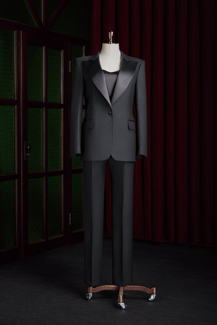 Women's tailored black tuxedo suit with satin lapels, designed for formal events, showcasing high-end sustainable fashion and sophisticated elegance.