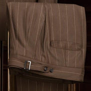 Close-up of brown pinstripe tailored trousers with adjustable side tabs, showcasing fine craftsmanship and sophisticated detailing, ideal for formal wear.