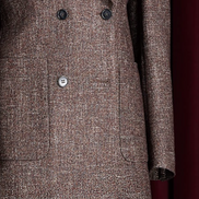 Detailed view of brown tweed blazer for women, featuring double-breasted buttons and a textured fabric, perfect for a high-end, eco-conscious look.