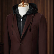 Close-up of men's burgundy blazer with single-button closure, layered over a black zip-up hoodie. Ideal for a sophisticated, casual look blending comfort and style. Perfect for eco-conscious individuals who value high-end, sustainable fashion.
