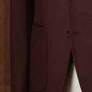 Close-up of men's burgundy blazer pocket and single-button detail, showcasing tailored craftsmanship and a refined finish. Ideal for eco-conscious shoppers seeking sustainable, high-end fashion.