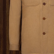 Close-up of camel-colored tailored jacket, highlighting button details and smooth sleeve finish. Crafted from sustainable materials, ideal for high-end formal wear.