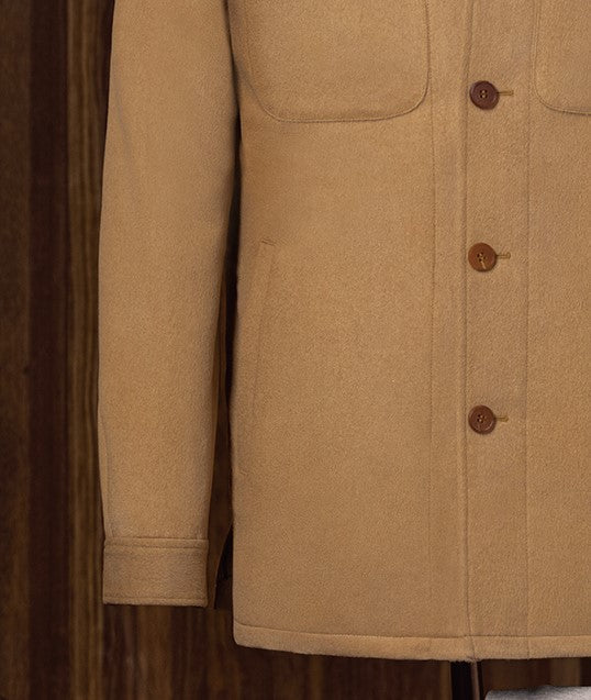 Close-up of camel-colored tailored jacket, highlighting button details and smooth sleeve finish. Crafted from sustainable materials, ideal for high-end formal wear.