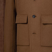 Close-up of camel tailored men's jacket with flap pockets and classic buttons, crafted from sustainable fabric for an eco-conscious and refined look.