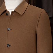 Close-up of a men's camel tailored jacket with a structured collar and classic buttons, showcasing fine craftsmanship and premium eco-friendly fabric for sustainable style.