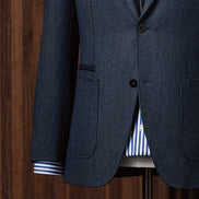 Close-up of navy blazer showcasing button details and pocket stitching by POLLHEIM. Modern tailoring that blends casual elegance and craftsmanship.