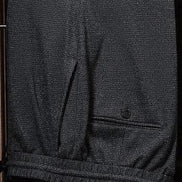 Close-up of charcoal grey suit trousers, showcasing fine textured fabric, precise tailoring, and back pocket detail, perfect for a sophisticated formal look.