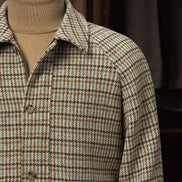 Close-up of a checked field jacket showcasing fine tailoring, a classic collar, and eco-friendly fabric in a textured pattern, ideal for high-end formal wear.