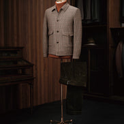 Mannequin displaying a tailored houndstooth field jacket paired with brown corduroy trousers, crafted from sustainable materials for an elegant formal look.