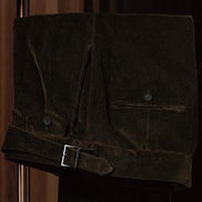 Close-up of brown corduroy trousers with belt detail, showcasing sustainable fabric and fine tailoring, perfect for an elegant, eco-friendly formal look.
