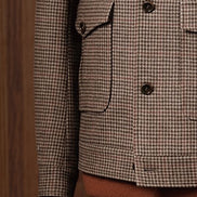 Close-up of houndstooth field jacket pocket and sleeve, showcasing sustainable fabric, refined tailoring, and classic design details, ideal for formal elegance.