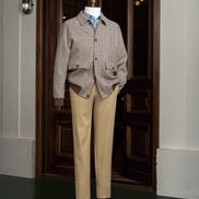 Full view of a tailored houndstooth sports coat paired with beige chinos on a mannequin, highlighting sustainable fashion and refined detailing for formal style