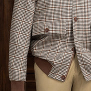 Close-up of houndstooth sports coat buttons and cuff with beige chinos, highlighting sustainable fabric, tailored detailing, and refined style for formal wear.