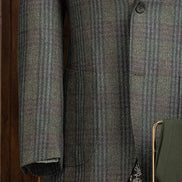 Close-up of checked wool jacket sleeve and pocket, showcasing fine tailoring and sustainable fabric, perfect for a sophisticated, eco-friendly style.