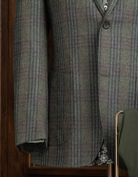Close-up of checked wool jacket sleeve and pocket, showcasing fine tailoring and sustainable fabric, perfect for a sophisticated, eco-friendly style.