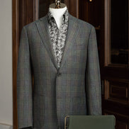 Close-up of a tailored checked wool jacket with olive trousers, showcasing sustainable materials and refined details for a sophisticated, eco-friendly formal look.