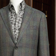 Close-up of checked wool jacket lapels and shoulder, featuring sustainable materials and detailed tailoring, ideal for a polished and refined formal look.