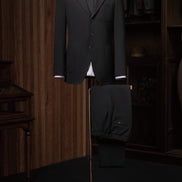 Full view of classic black tailored suit on a mannequin, exemplifying sustainable materials and timeless elegance for formal events.