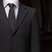 Close-up of black suit pocket and lapels, featuring tailored details and high-quality fabric, ideal for sophisticated formal occasions.