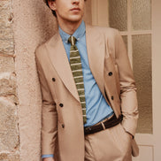 Full view of classic soft beige double-breasted suit, featuring a tailored fit, paired with a blue shirt and green tie, ideal for sophisticated, formal style.