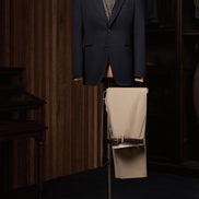 Classic navy blazer with beige trousers displayed on a mannequin. High-quality tailored clothing for women who desire a luxury feel for formal occasions.