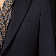 Detailed view of the navy blazer's peak lapels and pocket, showcasing fine tailoring for a sophisticated formal outfit for women.