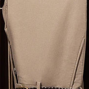 Close-up of beige tailored trousers with a stylish belt. Made from sustainable materials, ideal for a refined formal attire look.