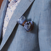 Detailed view of peak lapels and chest pocket on a coastal breeze blazer, showcasing fine tailoring and luxury fabric for a refined and sustainable style.