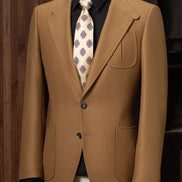 A dark beige suit jacket styled with a geometric tie, showcasing luxury tailoring and eco-conscious material, crafted for formal events and those who value refined, high-end fashion.