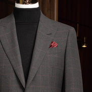 Dark grey checked jacket paired with a stylish red pocket square, showcasing luxury details perfect for upscale occasions.