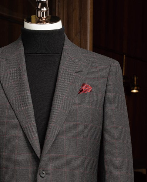 Dark grey checked jacket paired with a stylish red pocket square, showcasing luxury details perfect for upscale occasions.
