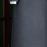 Close-up of the lower half of a dark grey long overcoat, showcasing the smooth wool fabric and double-breasted button detailing, perfect for stylish winter layering.