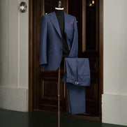 Men's deep blue check suit with refined peak lapels and tailored trousers, perfect for formal events and crafted with sustainable materials.