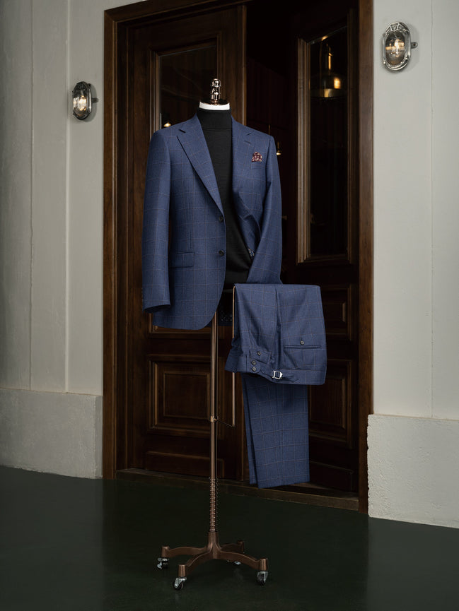 Men's deep blue check suit with refined peak lapels and tailored trousers, perfect for formal events and crafted with sustainable materials.