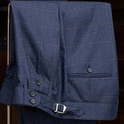 Deep blue check suit trousers with adjustable side tabs and button details for a tailored fit and refined style.