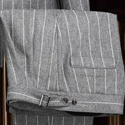 Close-up of light grey suit trousers, showcasing fine textured fabric, precise tailoring, and back pocket detail, perfect for a sophisticated formal look.