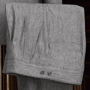 Close-up of grey suit trousers, showcasing fine textured fabric, precise tailoring, and back pocket detail, perfect for a sophisticated formal look.
