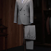 Elegant double-breasted wool suit on a mannequin, showcasing high-end tailoring for men. Perfect for formal events, crafted with sustainable materials.