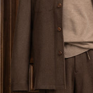 Close-up view of an earthy brown jacket and cargos, showcasing fine tailoring and sophisticated style for formal occasions.