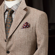 Elegant beige men's tweed blazer on a mannequin with a plaid shirt, floral tie, and pocket square Close up of the pocket square and peak lapels
