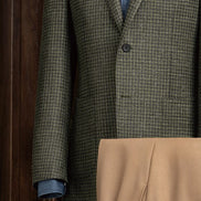 Close-up of the green checked jacket’s button detailing and precisely stitched sleeves, showcasing luxury craftsmanship and timeless style.