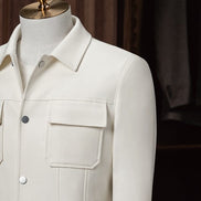 Upper close-up of The Couturist's white tailored jacket, featuring stylish patch pockets and collar. High-quality craftsmanship for women’s formalwear
