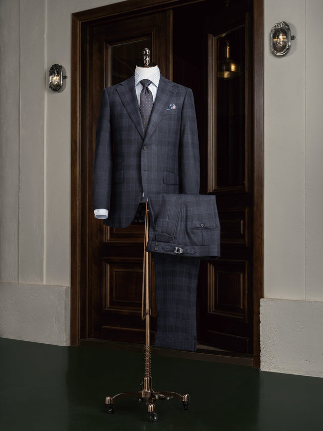 A stylish navy checked suit displayed on a mannequin, featuring a classic design perfect for formal and professional occasions