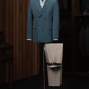 A chic teal double-breasted jacket paired with beige trousers, ideal for a refined and modern look.